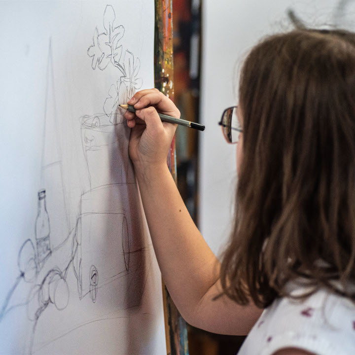 Dziewczynka uczy sie rysować martwą naturę podczas półkolonii wakacyjnych 2024
